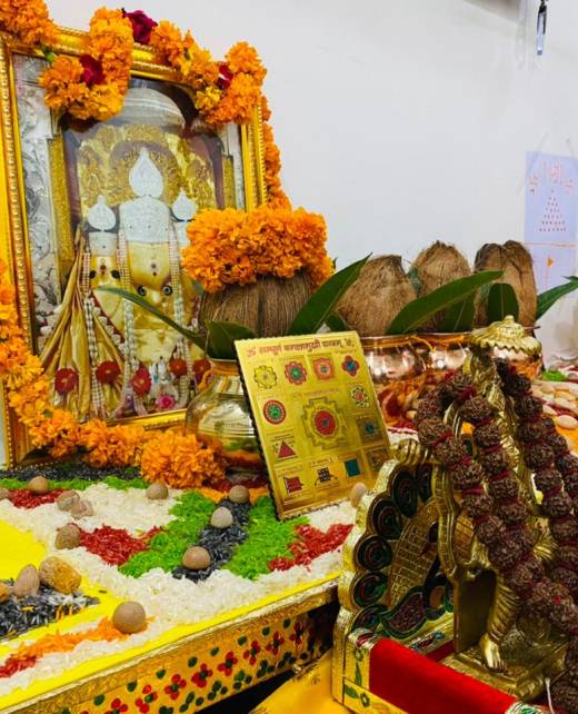 A vibrant image capturing the Baglamukhi Special Puja ceremony. Devotees gather around an ornate altar, immersed in prayer and ritual actions. Incense fills the air as they invoke the divine energies of Goddess Baglamukhi for blessings and empowerment.